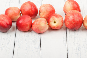Ripe red peaches on the white wooden table