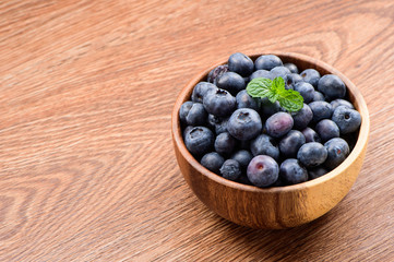 blueberry with vanilla mint in a wooden bowl on wooden background,top view
