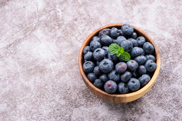 blueberry with vanilla mint in a wooden bowl on stone background,top view