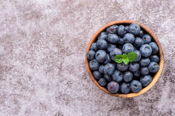 blueberry with vanilla mint in a wooden bowl on stone background,top view