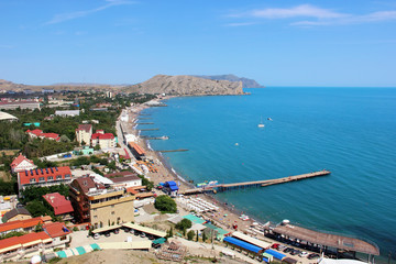 Fototapeta na wymiar The beach town of Sudak in Crimea, the view from the top of the mountain on a Sunny day.