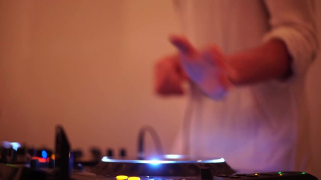 Hands of DJ tweak various track controls on dj's deck, camera is breathing