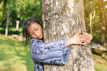 Girl hugging big tree color of hipster tone selective soft focus, concept nature and people