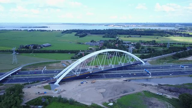 Aerial of bridge Zandhazenbrug over highway A1 in the Netherlands with NS Intercity train travels along