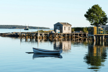 View of Bass Harbor with row boat, dock, labster traps, and fishing boat