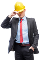 Man in business suit and yellow hard hat against white background isolated