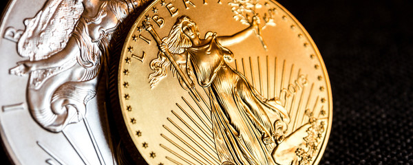 silver eagle and golden american eagle one ounce coins / closeup of silver eagle and golden...