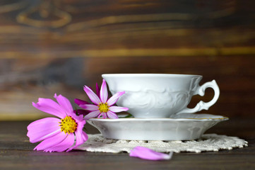 Fototapeta na wymiar Vintage tea cup and flowers on wooden table