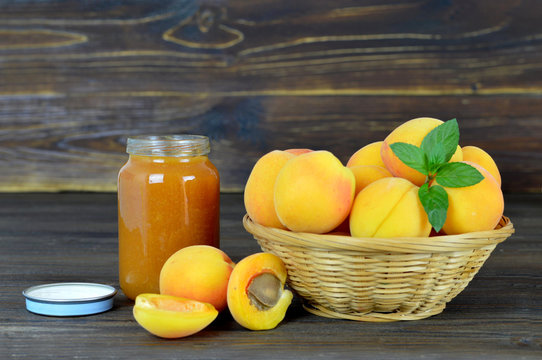Apricot jam and fresh apricots in the bowl on wooden table