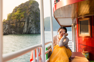 Naklejka premium Girl enjoying last sunshine on a cruise boat