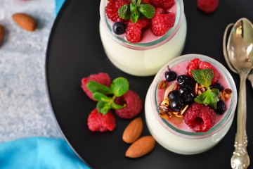 Vanilla yogurt with berries on a concrete background.