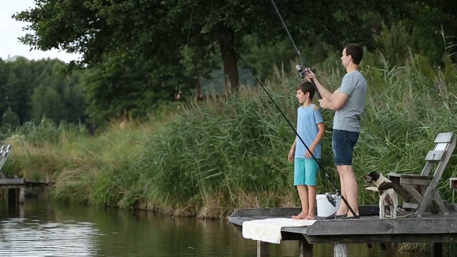 Hipster dad and boy enjoying fishing at the pond
