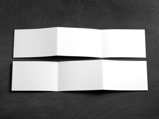 Blank folding page booklet on a black chalkboard.