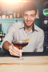 Bartender offers alcoholic cocktail in bar