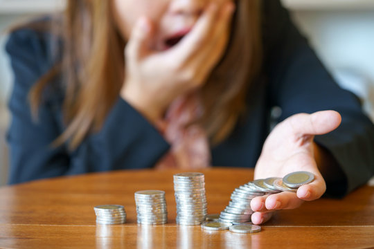 Shocked business woman with stack coins - stock and market down.