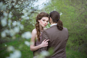 Young woman hugging a man in the flowered garden