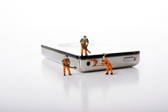 Miniature people with electronic hardwere over white background