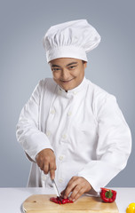 Portrait of chef cutting capsicum