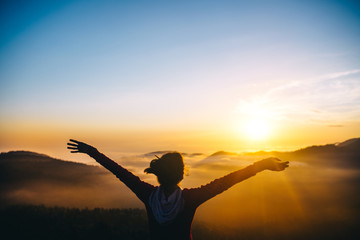 Fototapeta premium Man, tourist, over clouds in mountains at sunset feels freedom and happy