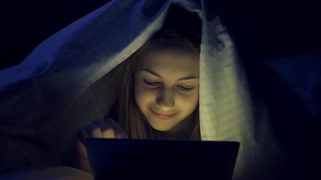 Cinemagraph - Girl on the bed with tablet. Motion Photo.