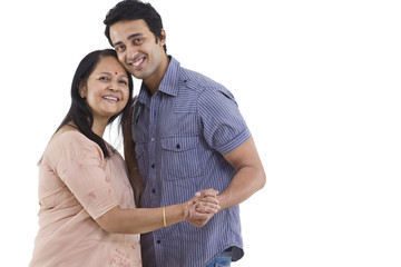 Obraz premium Portrait of mother and son dancing over white background 
