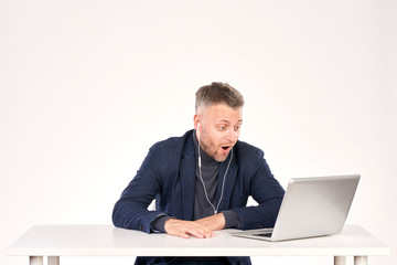 Portrait of middle-aged businessman sitting at office desk and having video call
