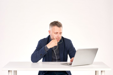 Portrait of middle-aged businessman sitting at office desk and having video call