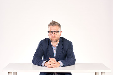 Portrait of pensive professor sitting at desk
