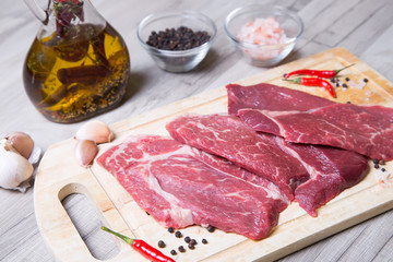 Raw marble beef on a wooden board. Selective focus.