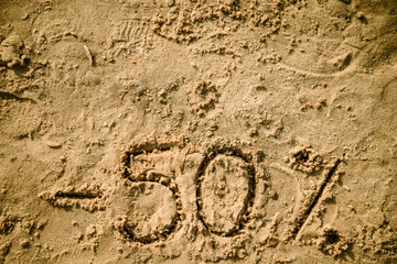 50 lettering written on sand