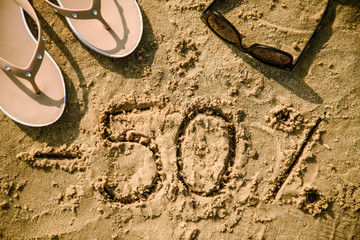 50 lettering written on sand