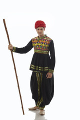 Portrait of a male dandiya dancer with a stick 