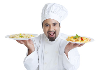 Portrait of chef holding plates with pasta