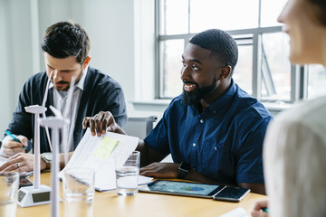 Smiling businessman sitting with colleagues during meeting