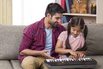 Father and daughter playing piano