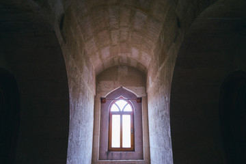 Fototapeta na wymiar Medieval architecture. Gothic style window in castle stone wall.