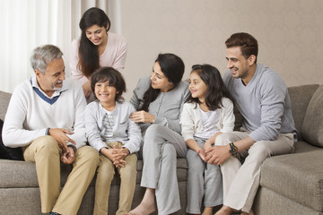 Fototapeta na wymiar Happy multi-generation family sitting together on sofa