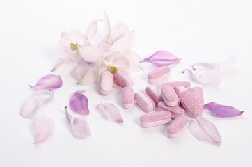 Fototapeta na wymiar Alternative medicine tablets with flowers and petals on table