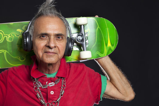 Close-up portrait of old man with skateboard 