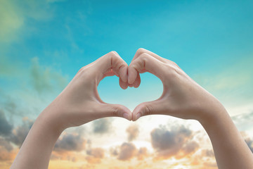 Human hands Heart shaped the sky in the background blurred.Environment Day concept. The power harmonious