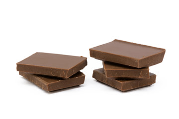 Milk chocolate pieces isolated on white background