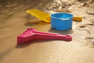 Fototapeta na wymiar Children's toys on the beach of the lake