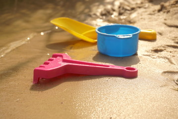 Fototapeta na wymiar Children's toys on the beach of the lake