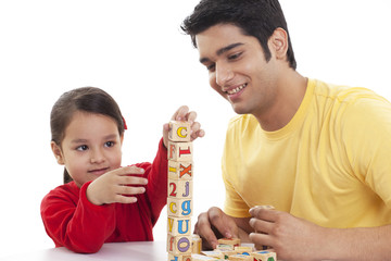 Father and child playing with blocks on white background 