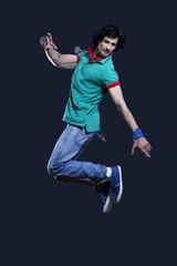 Young man jumping in mid air against black background 