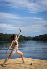Young Woman stretching on cedar dock