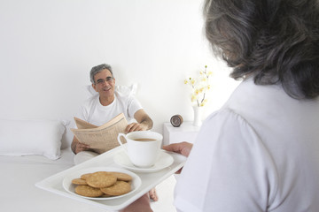 Wife serving tea to her husband