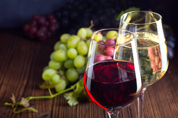 Glasses with red and white wine with grapes on wooden background - obrazy, fototapety, plakaty