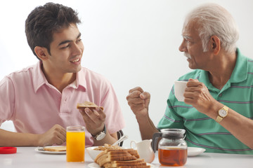 Fototapeta na wymiar Grandfather and grandson eating breakfast