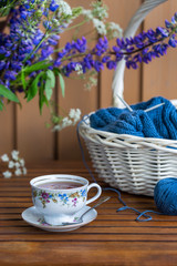 Still life with flowers,  knitting in the basket and cup of tea
